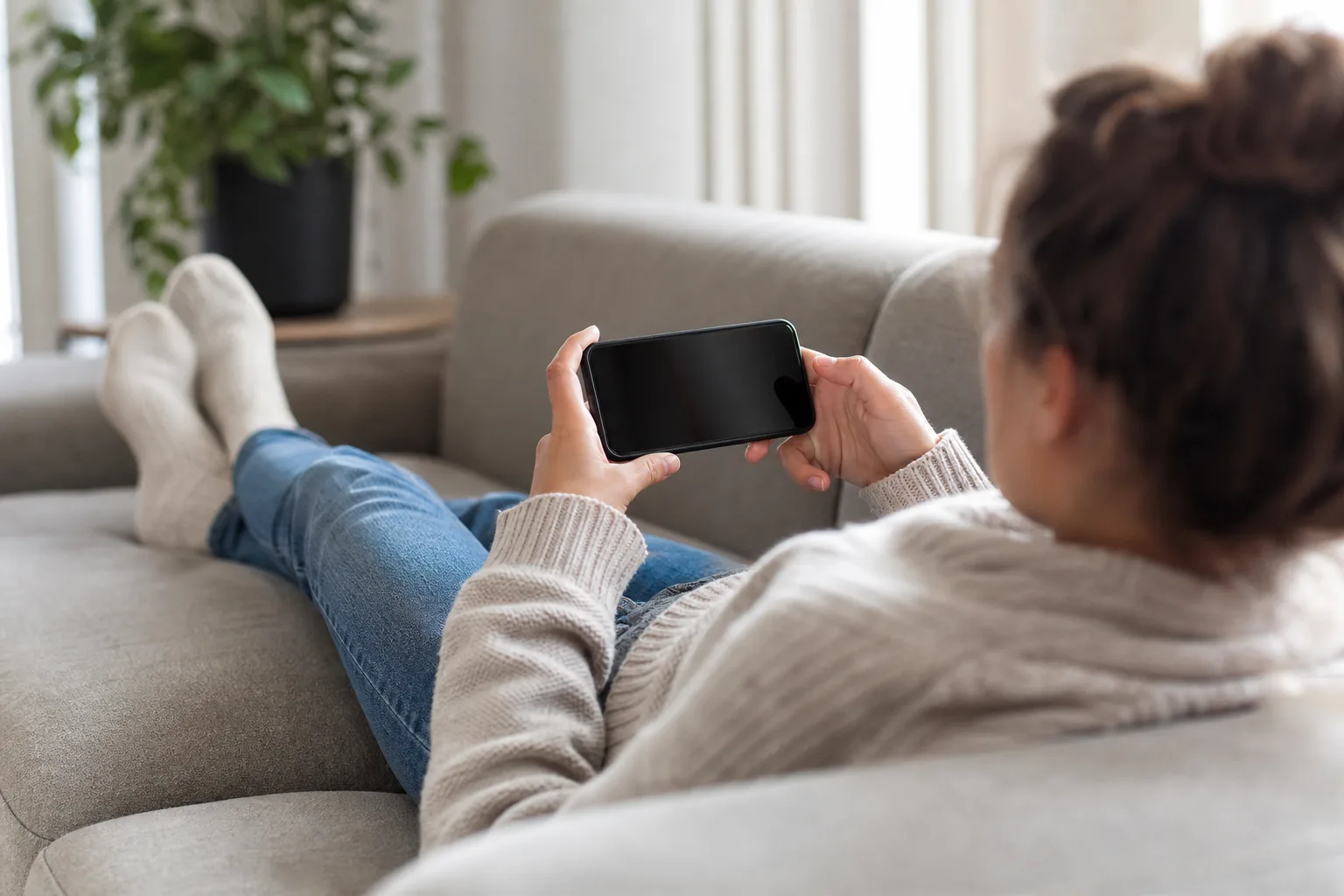 Film på en mobil med stor skärm i soffan – stor display för film och spel